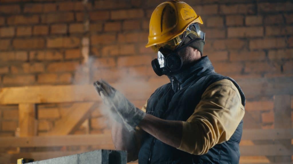A man works with a respirator at a construction site. You can use 1st Reporting for documenting inspections at your worksite.