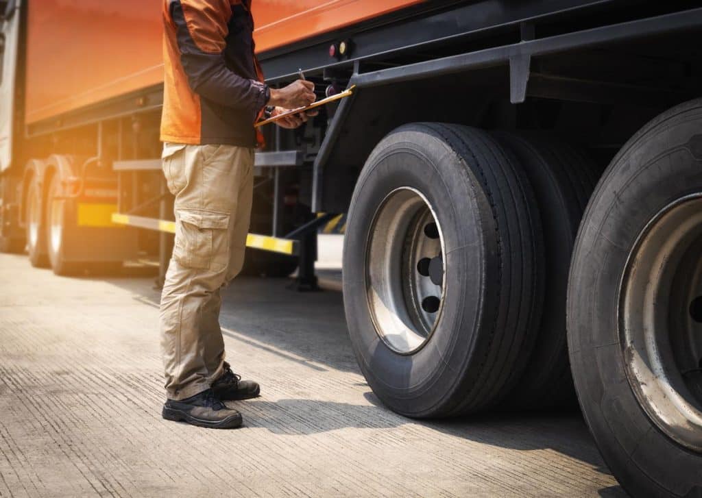 A mechanic performs a commercial trailer inspection. Learn more about mobile trailer inspection reporting at 1stReporting.com.