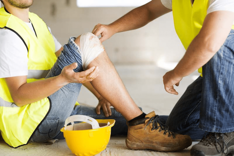 A worker gets treated for a knee injury following a trip and fall incident at work. Learn how to mitigate slip and fall incidents from 1stReporting.com.