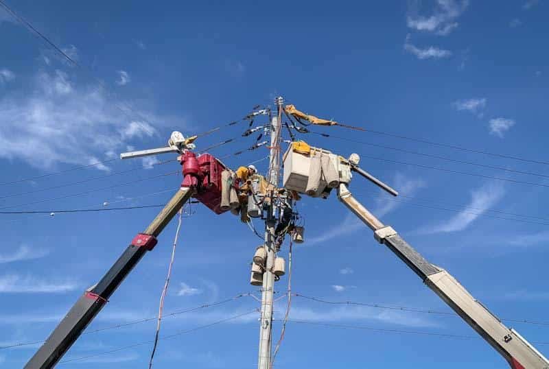 Utility workers work on power lines after completing a job hazard analysis using 1st Reporting.