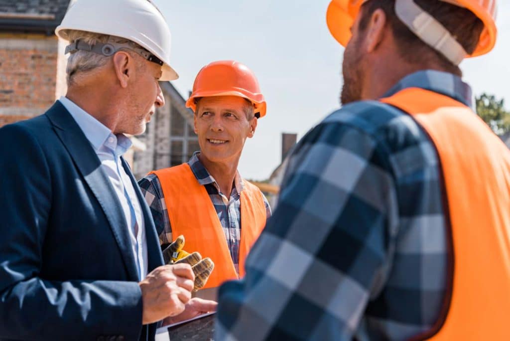 Top management loves efficient and effective systems as shown in this photo of a construction company executive reviewing and praising the site foreman's digital tailboard meeting form template. Learn more about tailboard meeting forms at 1stReporting.com.