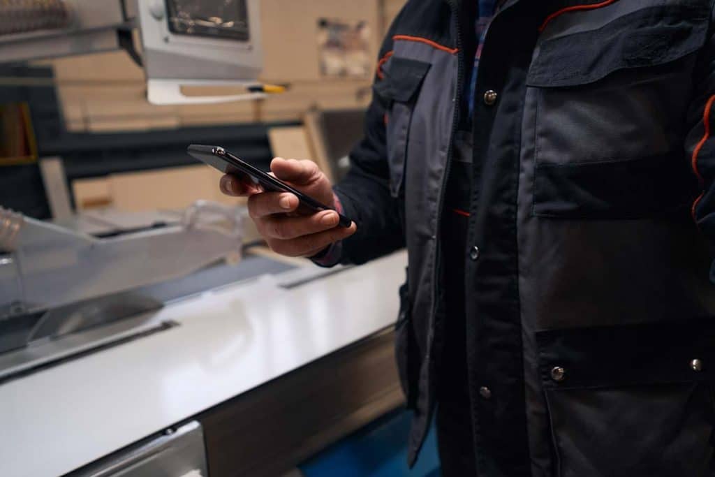 A mobile personnel member reviews his trip report form on his smartphone. Learn more about mobile field reporting at 1stReporting.com.